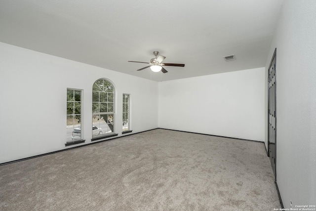 carpeted spare room featuring ceiling fan