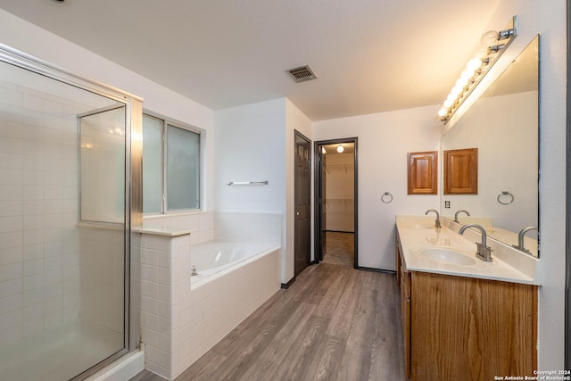 bathroom featuring vanity, independent shower and bath, and hardwood / wood-style flooring