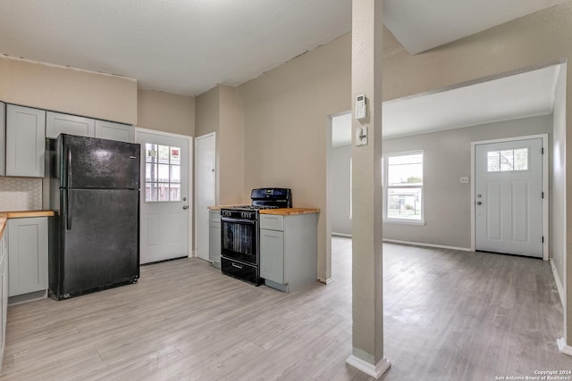 kitchen with butcher block countertops, black appliances, and light wood-type flooring