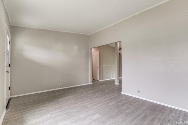 empty room with light hardwood / wood-style floors and ornamental molding