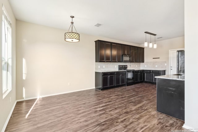 kitchen featuring pendant lighting, black appliances, tasteful backsplash, dark hardwood / wood-style flooring, and dark brown cabinetry