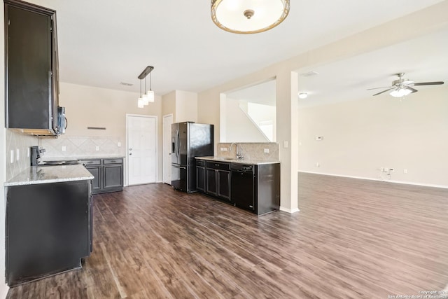 kitchen with decorative backsplash, appliances with stainless steel finishes, ceiling fan, pendant lighting, and dark hardwood / wood-style floors