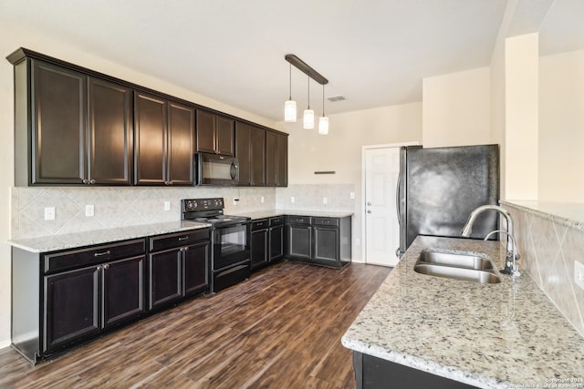 kitchen with light stone countertops, sink, black appliances, dark hardwood / wood-style floors, and hanging light fixtures