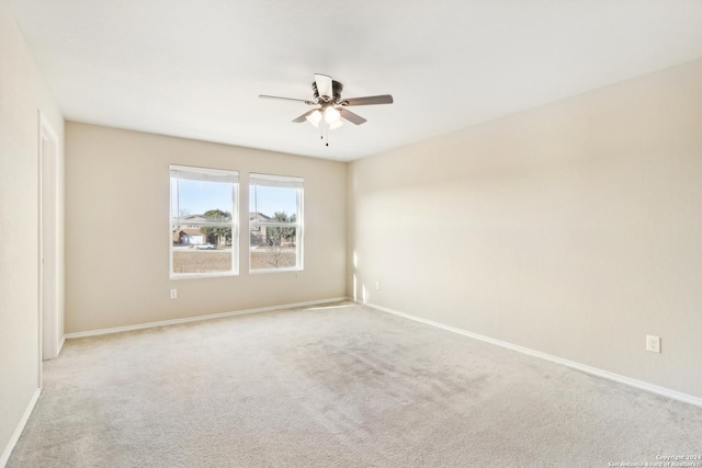 carpeted spare room with ceiling fan