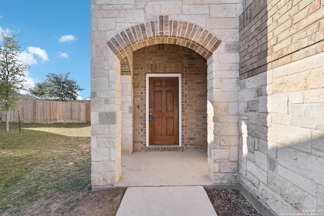 entrance to property featuring a lawn