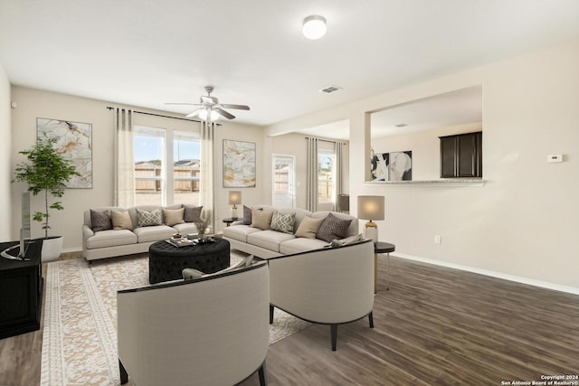 living room featuring ceiling fan and dark hardwood / wood-style floors