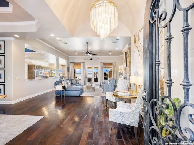 living room featuring ceiling fan with notable chandelier, dark hardwood / wood-style flooring, and crown molding