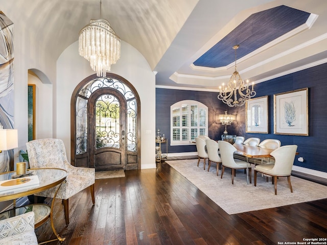 dining room with a tray ceiling, hardwood / wood-style floors, a chandelier, and ornamental molding