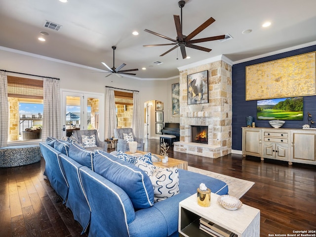 living room featuring a stone fireplace, crown molding, ceiling fan, and dark hardwood / wood-style floors