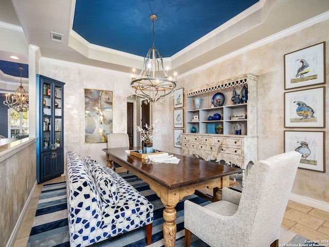 dining room featuring a tray ceiling, crown molding, and a notable chandelier