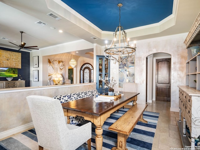 dining room with a tray ceiling, crown molding, and ceiling fan with notable chandelier