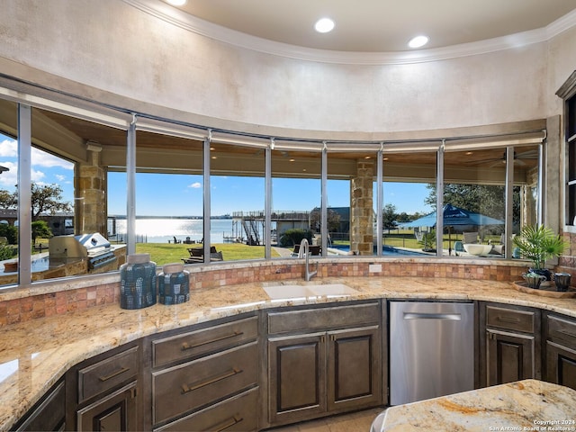 kitchen with a water view, sink, stainless steel dishwasher, ornamental molding, and dark brown cabinets