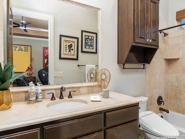 full bathroom featuring vanity, ceiling fan, toilet, and tiled shower / bath