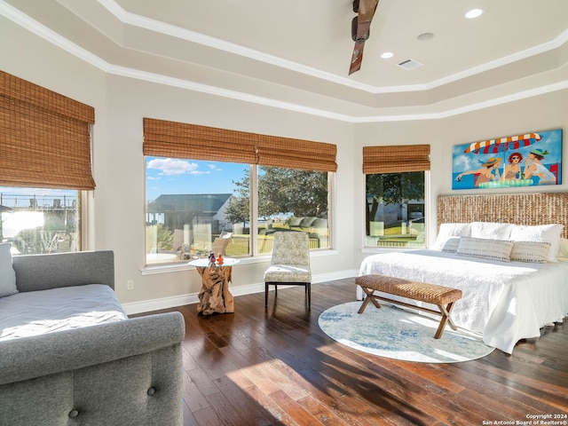 bedroom with a tray ceiling, crown molding, and dark hardwood / wood-style flooring