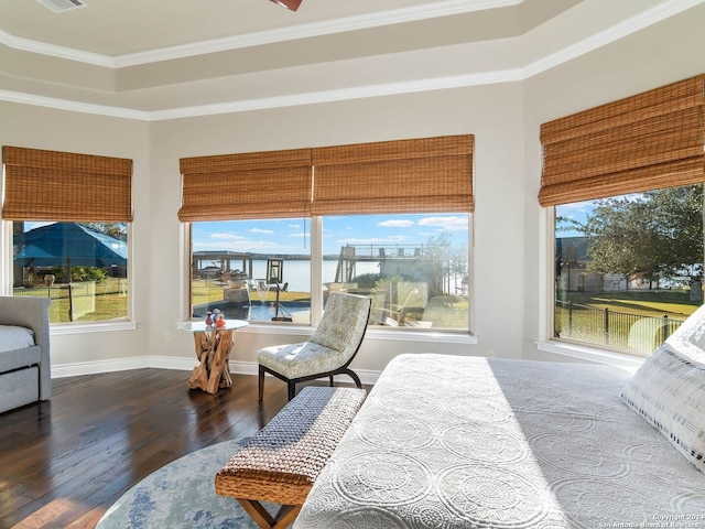 bedroom with a raised ceiling, dark hardwood / wood-style flooring, a water view, and ornamental molding