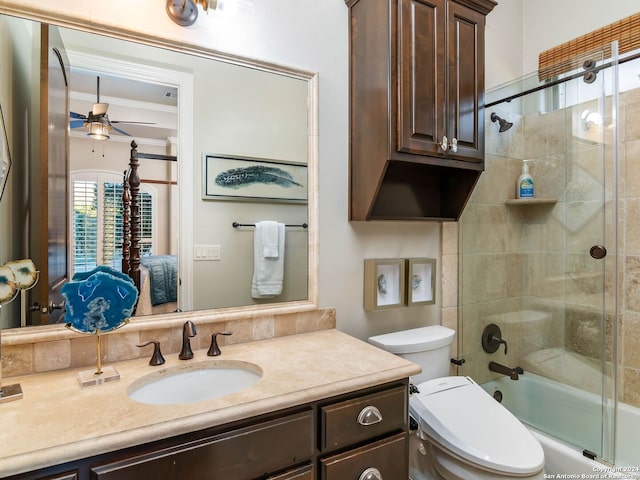 full bathroom with ceiling fan, bath / shower combo with glass door, toilet, vanity, and ornamental molding