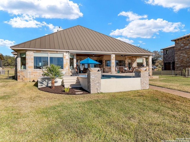 back of property with a lawn, a patio area, ceiling fan, and a swimming pool