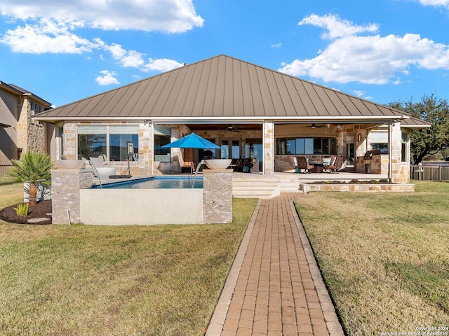 rear view of house with ceiling fan, a yard, and a patio