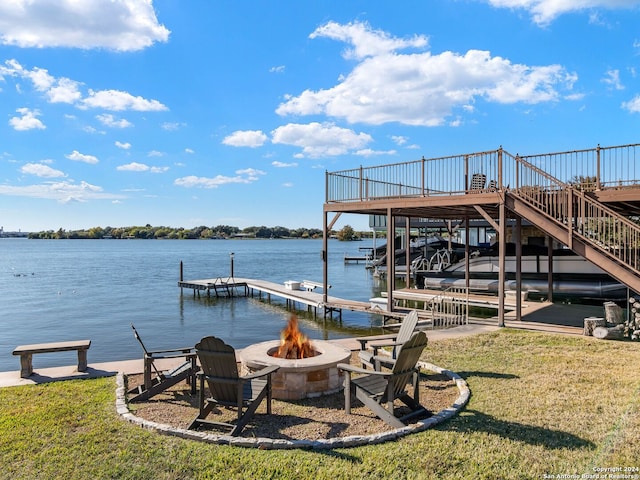 view of dock featuring a lawn, a water view, and an outdoor fire pit