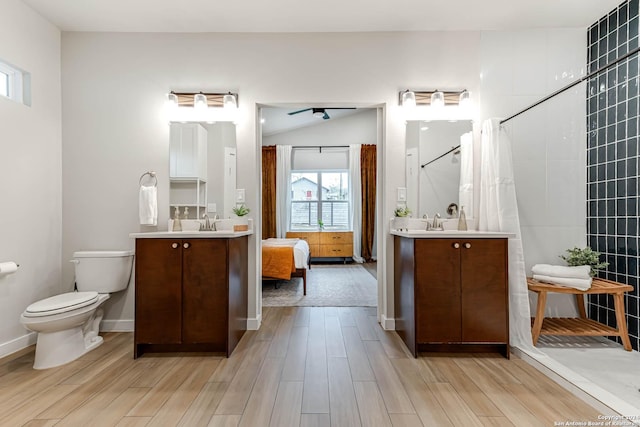 bathroom featuring ceiling fan, sink, a shower with curtain, toilet, and hardwood / wood-style flooring