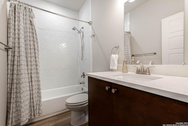 full bathroom featuring hardwood / wood-style flooring, shower / bath combination with curtain, toilet, and vanity