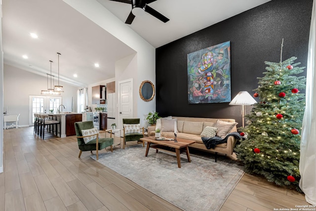 living room with french doors, light hardwood / wood-style flooring, vaulted ceiling, and ceiling fan