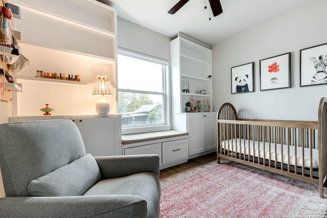 bedroom with a crib, light hardwood / wood-style flooring, and ceiling fan