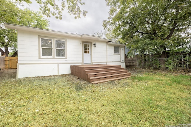 rear view of property with a lawn and a deck