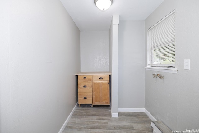 laundry area with light hardwood / wood-style floors