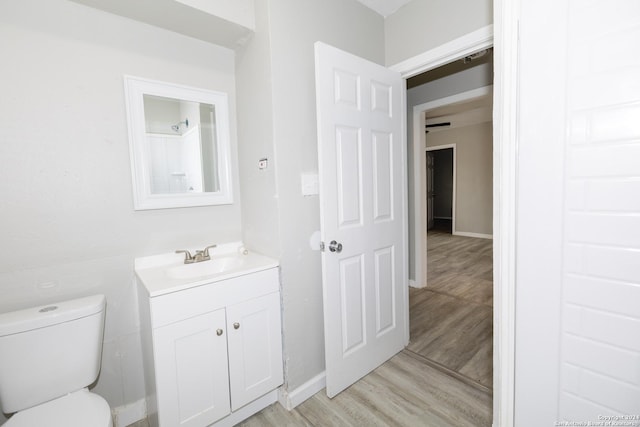 bathroom with wood-type flooring, vanity, and toilet