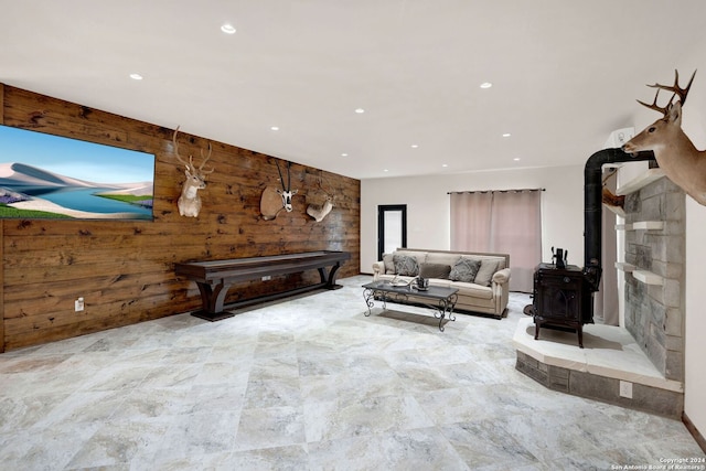 living room featuring a wood stove and wooden walls