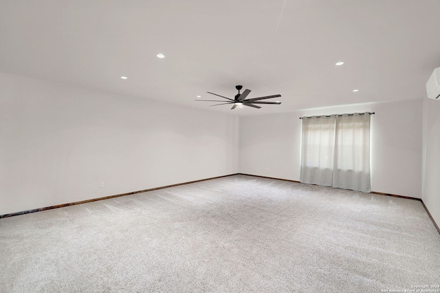 spare room with a wall unit AC, light carpet, and ceiling fan