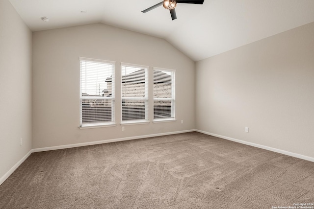 carpeted spare room with ceiling fan and lofted ceiling