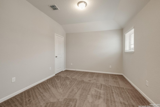 unfurnished room featuring carpet floors and lofted ceiling