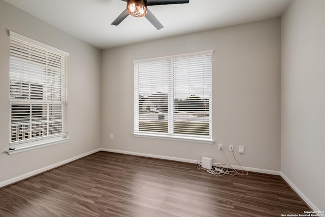 empty room with dark hardwood / wood-style flooring and ceiling fan