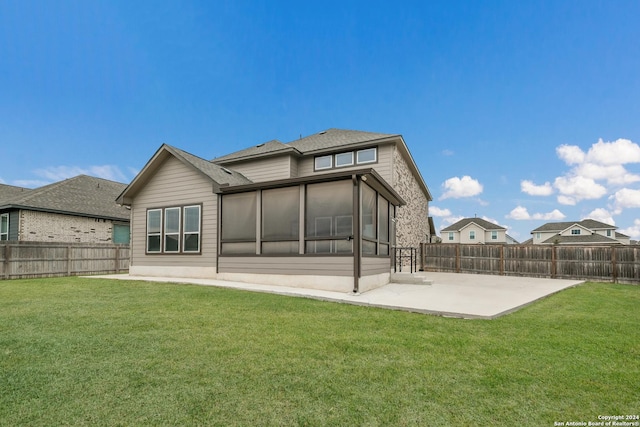 rear view of property featuring a yard, a patio area, and a sunroom