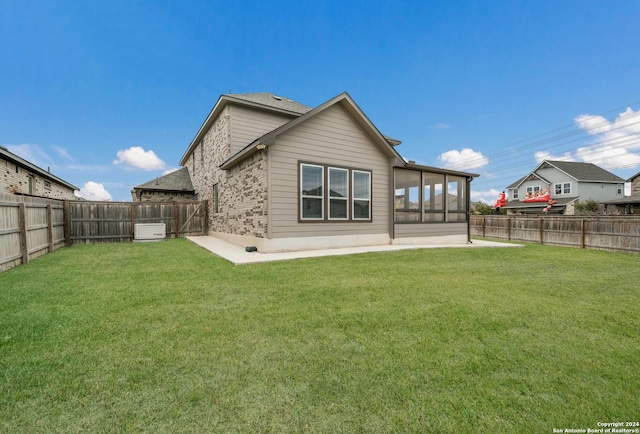 rear view of house featuring a sunroom and a yard