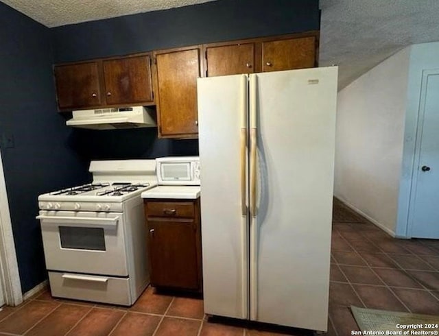 1254 Encino Dr, Pleasanton, TX 78064 - kitchen featuring white appliances, under cabinet range hood, dark tile patterned floors, a textured ceiling, and light countertops