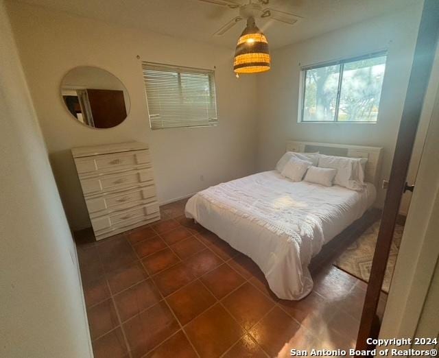 1254 Encino Dr, Pleasanton, TX 78064 - bedroom with multiple windows and dark tile patterned flooring