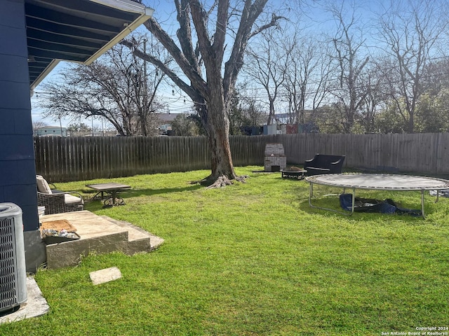 view of yard featuring central AC, a patio, and a trampoline