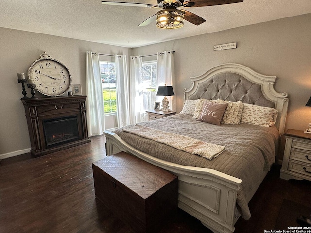 bedroom with a textured ceiling, dark hardwood / wood-style floors, and ceiling fan