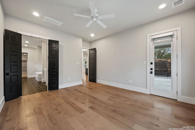 unfurnished bedroom with ceiling fan, access to exterior, and dark wood-type flooring