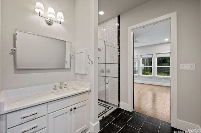 bathroom with hardwood / wood-style floors, vanity, a shower with door, and ceiling fan