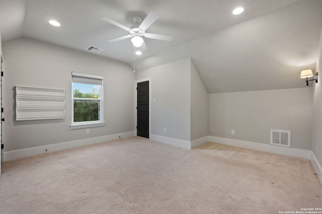 additional living space with ceiling fan, light colored carpet, and lofted ceiling