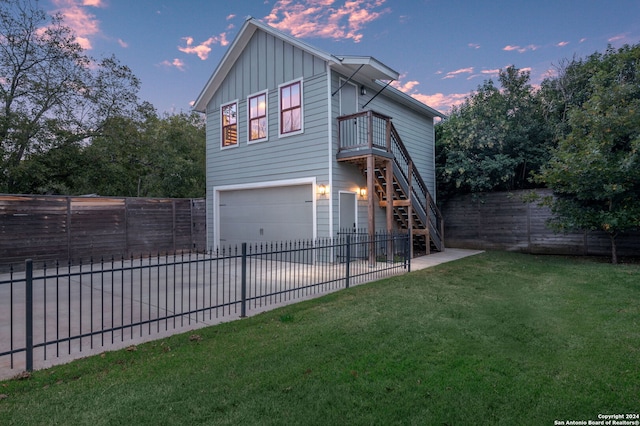 property exterior at dusk featuring a yard, a balcony, and a garage