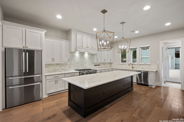 kitchen featuring white cabinets, a center island, stainless steel appliances, and dark hardwood / wood-style floors