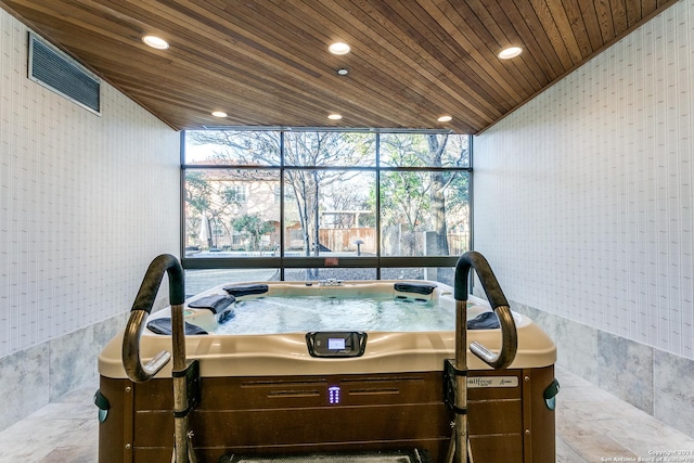 interior space with lofted ceiling, wooden ceiling, tile walls, and a jacuzzi