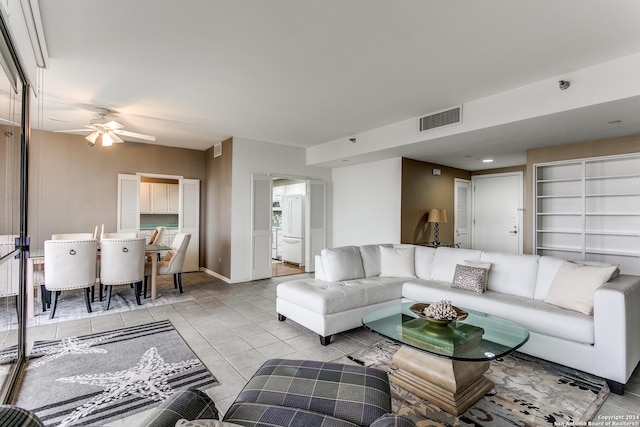 tiled living room with ceiling fan and a healthy amount of sunlight