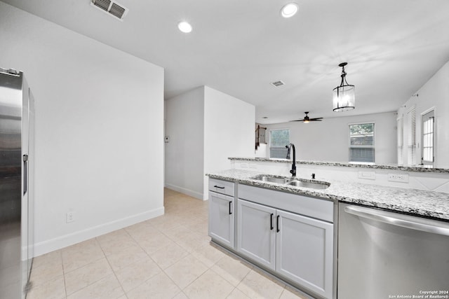 kitchen with appliances with stainless steel finishes, light stone counters, ceiling fan, sink, and decorative light fixtures