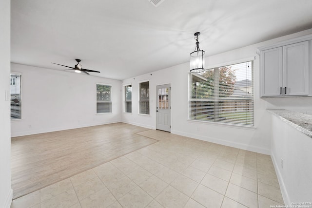 interior space featuring ceiling fan with notable chandelier and light wood-type flooring